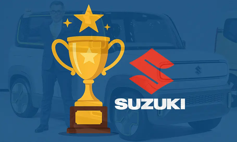 Suzuki-Chef Toshihiro Suzuki Eine Grafik von einem Pokal sowie dem Suzuki-Logo, im Hintergrund ist ein Suzuki-Fahrzeug.