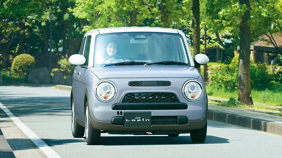 Der Suzuki Lapin fahrend von schräg vorne rechts.