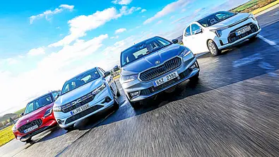Blick von vorne auf die vier Kleinwagen Suzuki Swift, Dacia Sandero, Skoda Fabia und Kia Picanto, die in Formation nebeneinander her fahren. - Foto: Daniela Loof