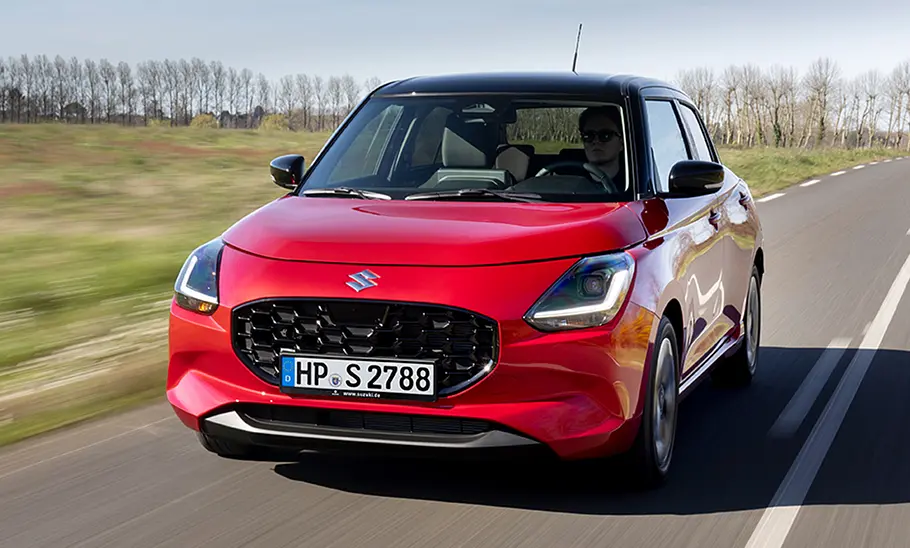 Der Suzuki Swift fahrend auf einer Straße in der Frontansicht.