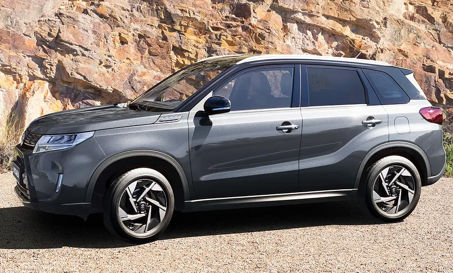 Suzuki Vitara steht vor einer Felswand, Ansicht von der linken Seite.