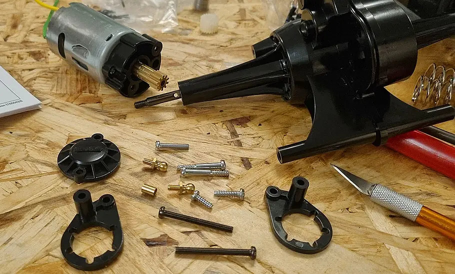 Das Bild zeigt das den Aufbau des Chassis des Tamiya Lunch Box. Die Bauteile sind auf einem Tisch verteilt.