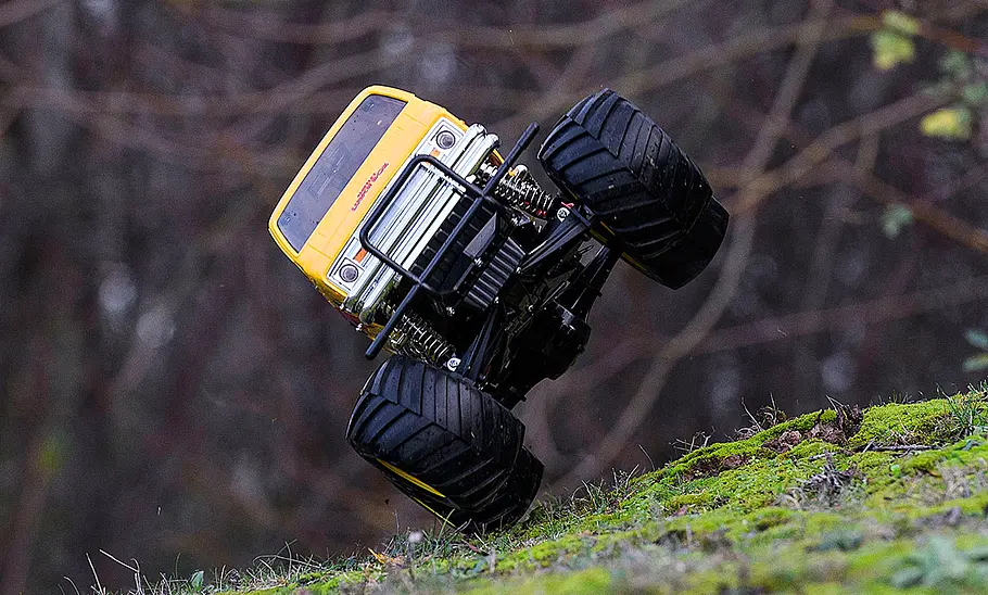 Das Bild zeigt den Tamiya Lunch Box fahrend von vorne fotografiert. Das Modell fährt auf zwei Rädern nach links gekippt.
