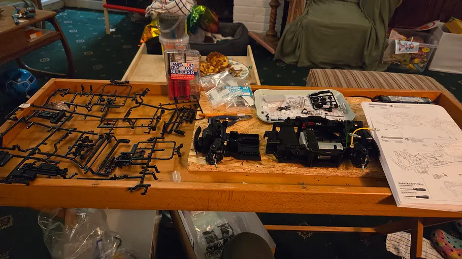 Der Aufbau des Tamiya Mini MB-01 im Test. Alle Einzelteile liegen samt Anleitung auf einem Tisch.