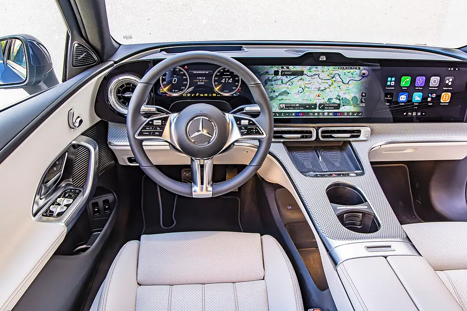 Mercedes C 400 4Matic elektrisch Cockpit Das Cockpit der elektrischen C-Klasse mit breitem Bildschirm und hellen Sitzen.