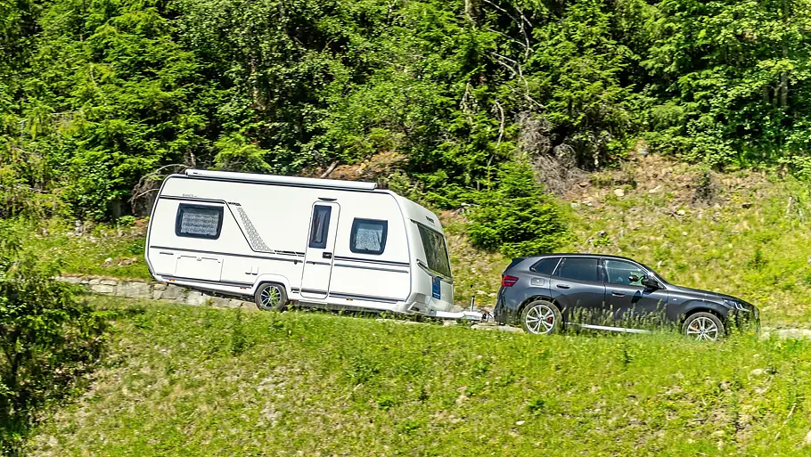 Tirol-Reisereportage im Fendt Bianco Das Gespann aus BMW X3 und Fendt Bianco fahrend auf einer abschüssigen Straße.