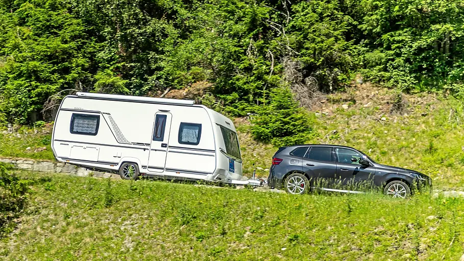Tirol-Reisereportage im Fendt Bianco Das Gespann aus BMW X3 und Fendt Bianco fahrend auf einer abschüssigen Straße.