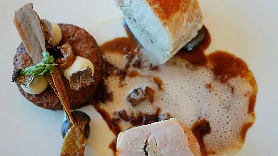 Tirol-Reisereportage im Fendt Bianco Schweinefilet mit Sauce auf einem Teller angerichtet von oben fotografiert.