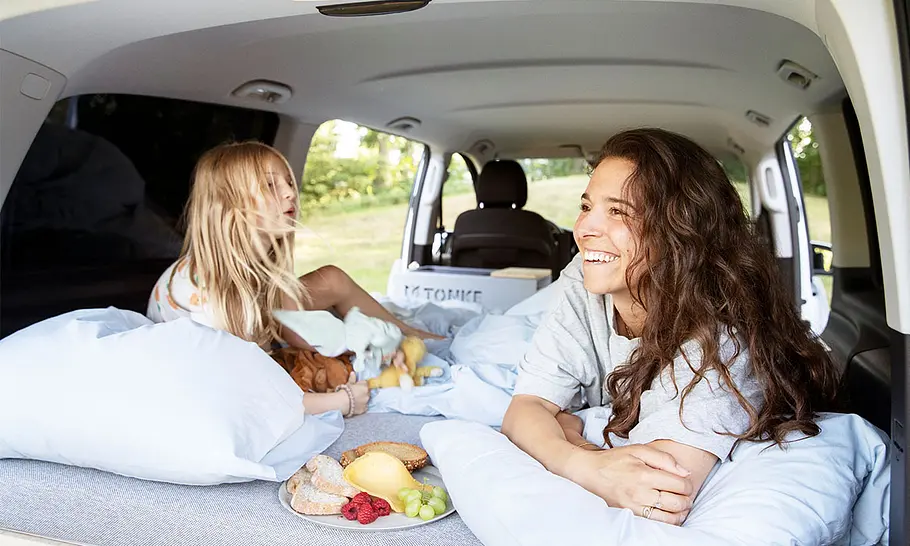 Außenaufnahme zeigt das Heckschlafzimmer mit Mutter und Kind.