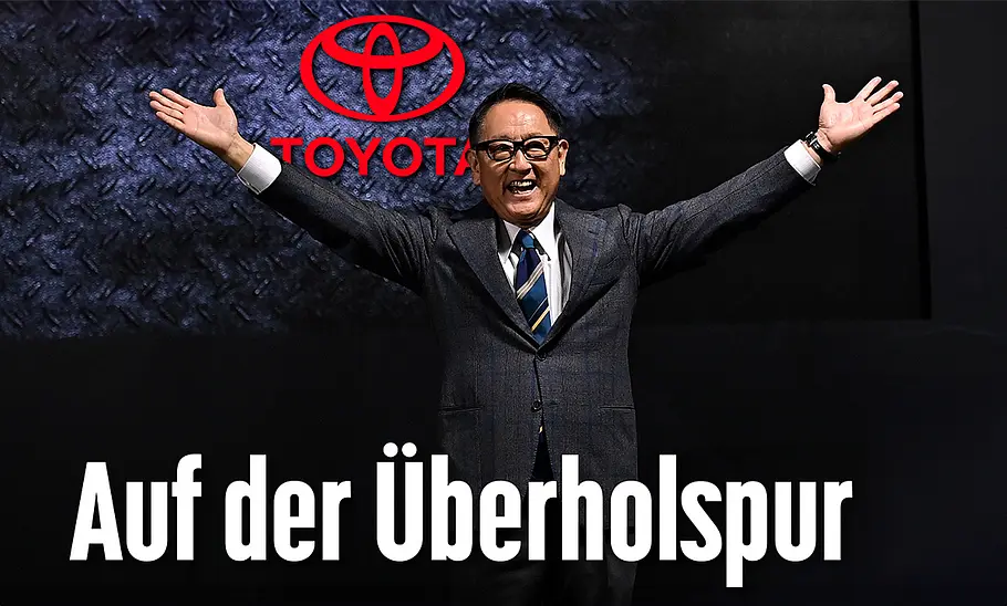 Akio Toyoda streckt triumphierend die Hände hoch.