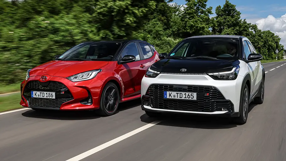Toyota Aygo X und Toyota Yaris fahren auf einer Landstraße nebeneinander. Ansicht von vorne.