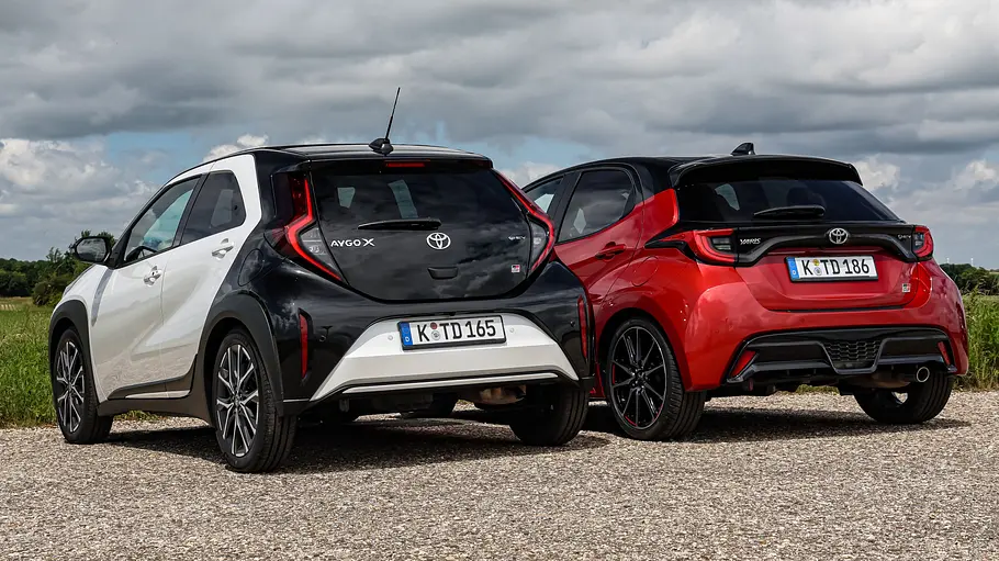 Toyota Aygo X und Toyota Yaris statisch nebeneinander von hinten.
