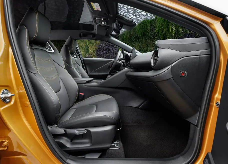 Die Vordersitze des Toyota C-HR von der Seite durch die geöffnete Tür fotografiert.