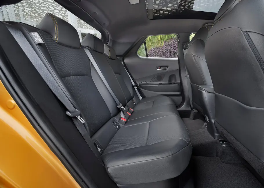 Die Rücksitzbank des Toyota C-HR von der Seite durch die geöffnete Tür fotografiert.