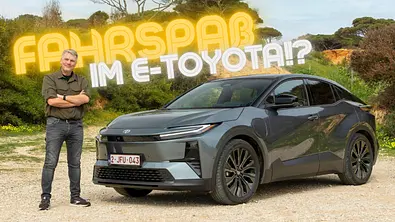 Toyota C-HR+ statisch mit Moderator Martin Urbanke auf einem Schotterparkplatz in der Natur. - Foto: Toyota C-HR+