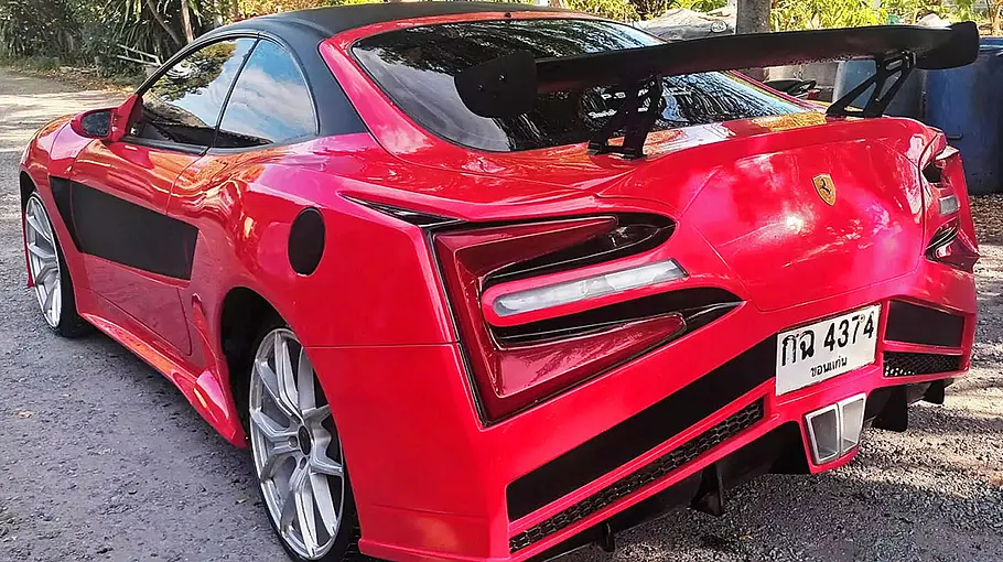 Diw Toyota Celica T20 im Ferrari-F12-Look stehend von schräg hinten.