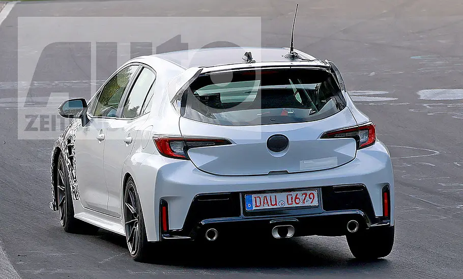 Toyota Corolla GRMN (2025) Toyota GR Corolla Facelift (2024); Blick von schräg links hinten auf den fahrenden, teilweise getarnten Corolla.