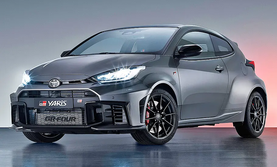 Toyota GR Yaris Facelift (2024) Das Toyota GR Yaris Facelift (2024) steht in Studioumgebung, von vorne links fotografiert.