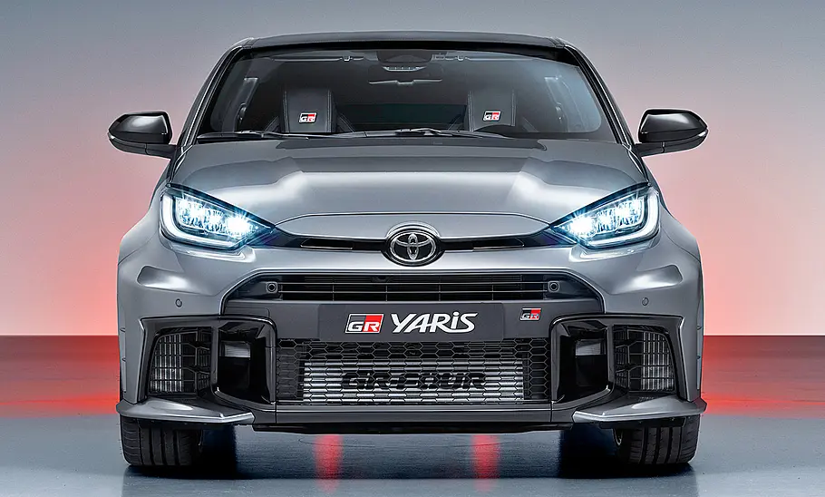 Toyota GR Yaris Facelift (2024) Das Toyota GR Yaris Facelift (2024) steht in Studioumgebung, von vorne fotografiert.