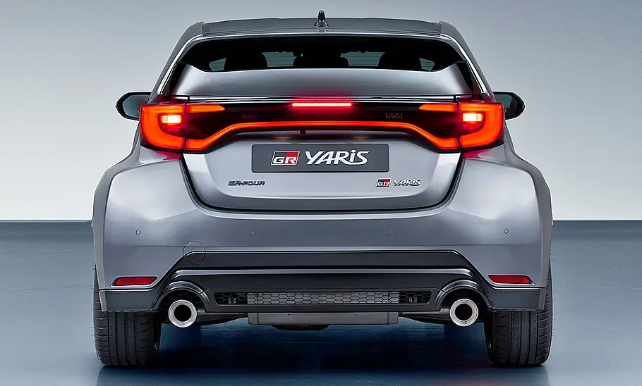 Toyota GR Yaris Facelift (2024) Das Toyota GR Yaris Facelift (2024) steht in Studioumgebung, von hinten fotografiert.