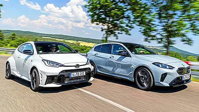 Blick von schräg vorne auf die beiden fahrenden Kompaktsportler Toyota GR Yaris und BMW M135. - Foto: Frank Ratering