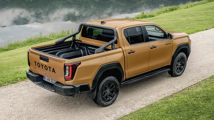 Toyota Hilux 2.8 D Der Toyota Hilux 2.8 D statisch von schräg hinten rechts auf einer Schotterweg.