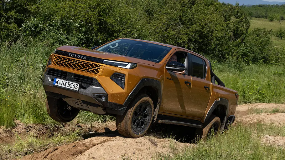 Toyota Hilux 2.8 D Der Toyota Hilux 2.8 D dynamisch im Gelände von schräg vorne links.