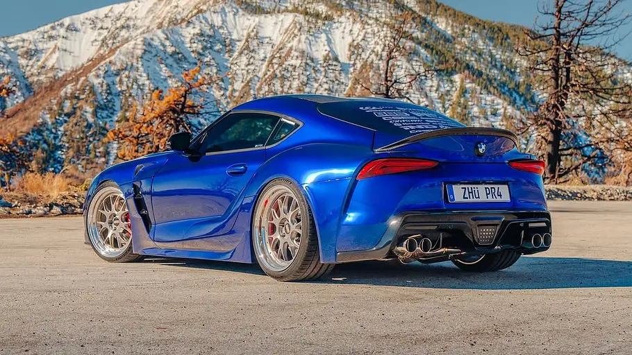 Toyota Supra mit Z4-Front Der Toyota Supra mit Z4-Front steht vor einem Bergpanorama, von hinten links fotografiert.