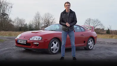 AUTO ZEITUNG-Redakteur Max Grigo steht vor der Toyota Supra Mk4. - Foto: AUTO ZEITUNG