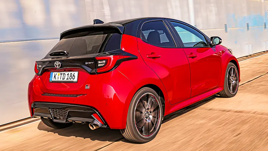 Blick von schräg hinten auf den fahrenden Toyota Yaris.