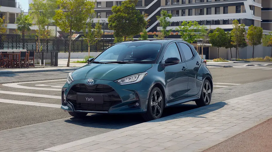 Toyota Yaris Der Toyota Yaris steht vor einem Gebäude, von vorne links fotografiert.