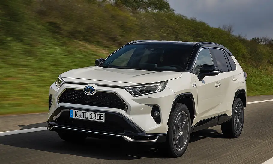 Der Toyota RAV4 fahrend auf einer Straße von schräg vorne.