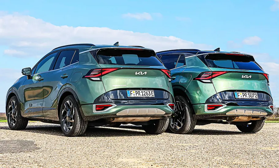 Kia Sportage PHEV/Diesel Blick von schräg hinten auf die beiden stehen Kia Sportage 1.6 T-GDI Plug-in-Hybrid und 1.6 CRDi 48V AWD.