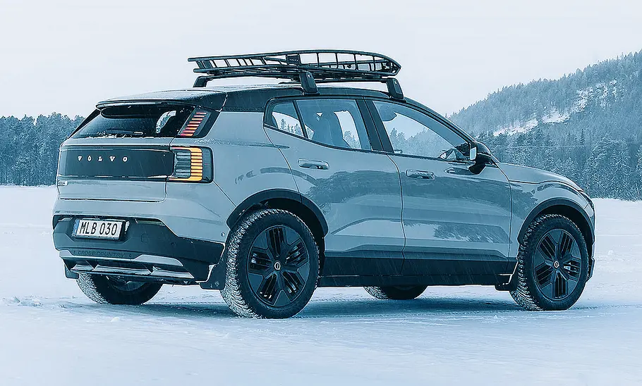 Blick von schräg hinten auf den Volvo EX30 Cross Country (2025). Im Hintergrund eine verschneite Landschaft.