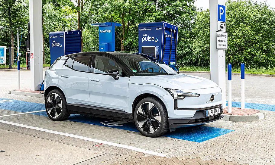 Der Volvo EX30 Single Motor Extended Range Ultra steht an einer Aral-Ladesäule, fotografiert von schräg vorne.
