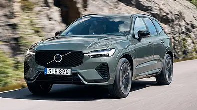 Der Volvo XC60 (2025) fährt auf einer Landstraße, von schräg vorne fotografiert. - Foto: Volvo
