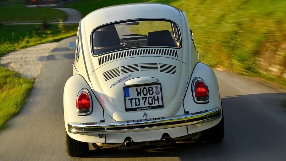 VW 1302 Theo-Decker-Käfer fahrend von hinten fotografiert. 