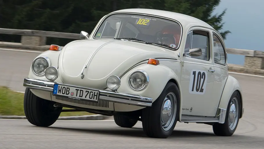 VW 1302 Theo-Decker-Käfer fahrend von schräg vorne fotografiert. 