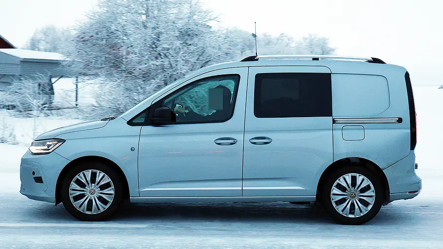 Blick von der Seite auf den fahrenden Erlkönig des VW Caddy Facelift (2026).