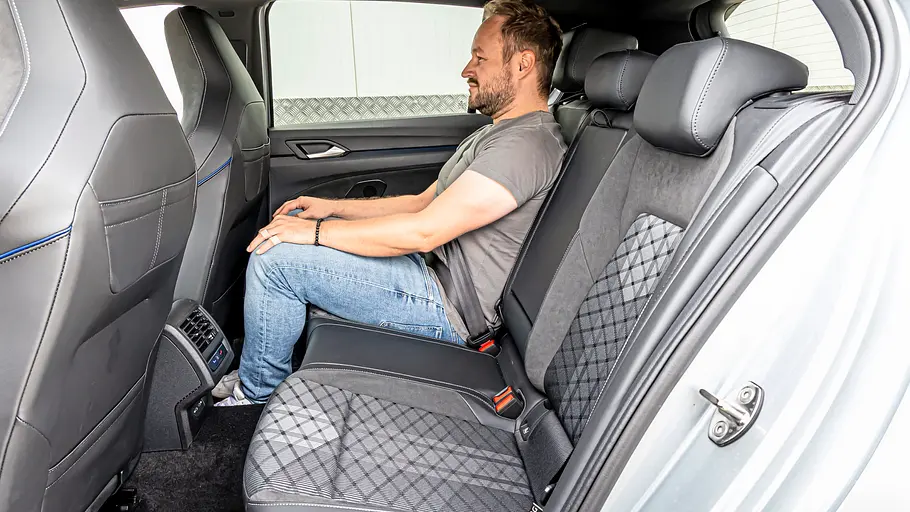 Ein Mann sitzt auf der Rückbank des VW Golf und verdeutlicht die Beinfreiheit im Fond.