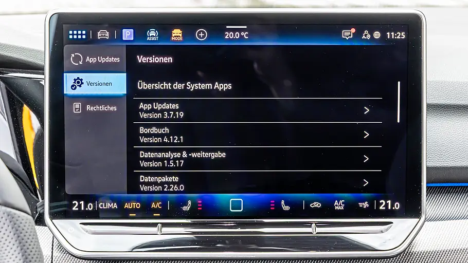 Ein Touchscreen im VW Golf zeigt unter „Versionen“ eine Übersicht der System-Apps. Am unteren Rand sind Klimabedienelemente zu sehen.