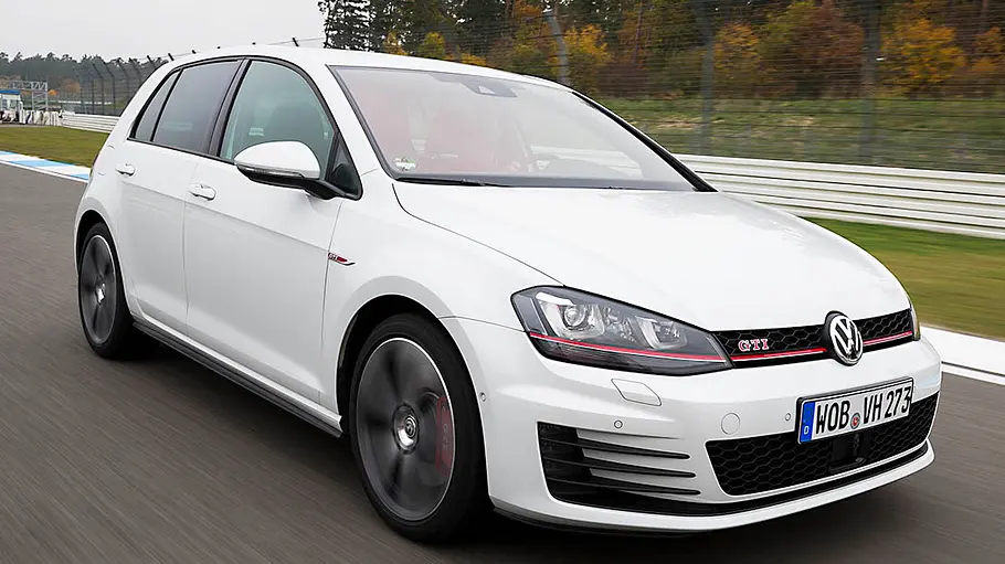 Der VW Golf 7 GTI fahrend von schräg vorne fotografiert.