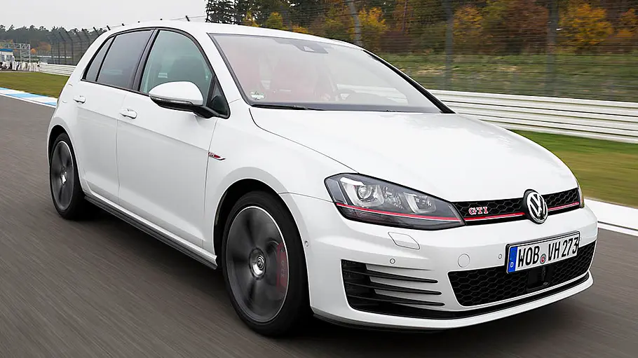 Der VW Golf 7 GTI fahrend von schräg vorne fotografiert.