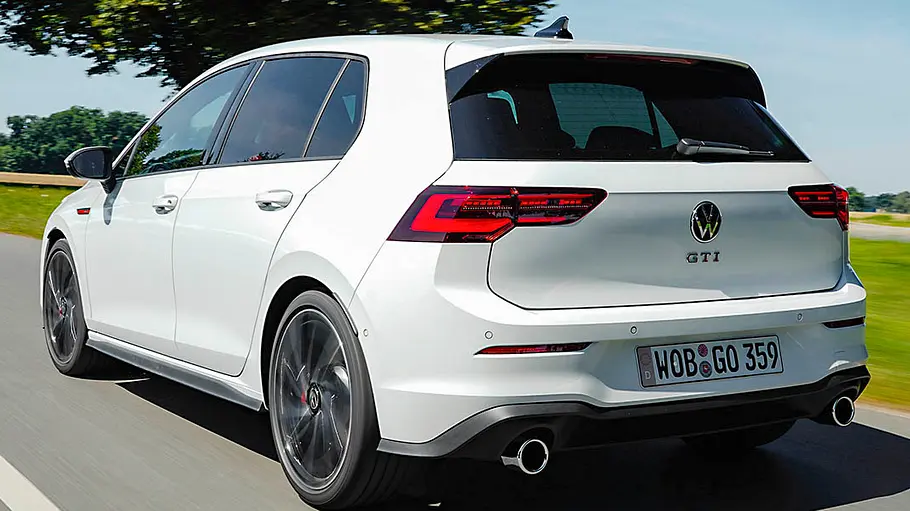 Der VW Golf 8 GTI fahrend von schräg hinten fotografiert.