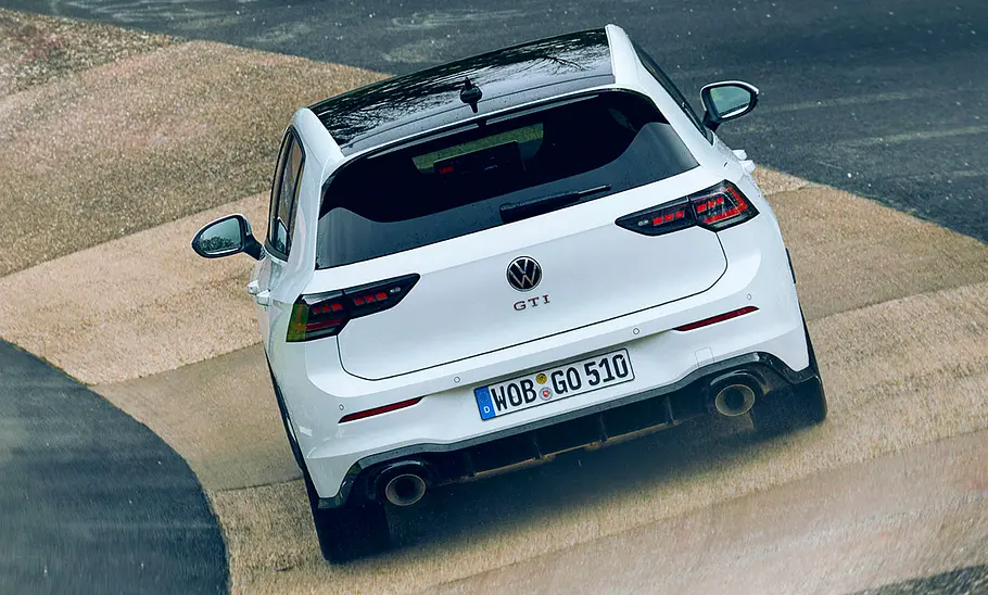 VW Golf GTI Clubsport Facelift (2024): Blick von hinten auf ein fahrendes Auto auf der Rennstrecke.