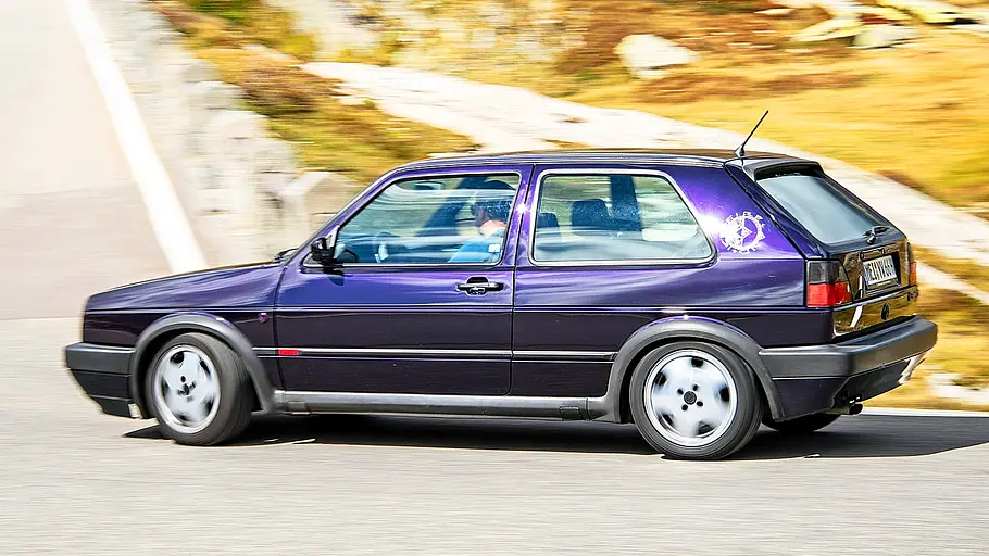 Blick von der Seite auf den fahrenden VW Golf GTI Fire + Ice.