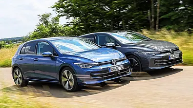 Blick von schräg vorne auf die beiden fahrenden Kompakten VW Golf Diesel und VW Golf Mildhybrid. - Foto: Daniela Loof