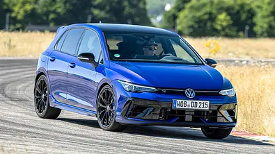 Der VW Golf R fährt auf einer Rundstrecke durch eine Linkskurve, von vorne fotografiert. - Foto: Frank Ratering
