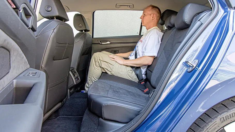 Blick durch die geöffnete linke Hintertüre auf die Rückbank des VW Golf Variant, auf der eine Person sitzt.