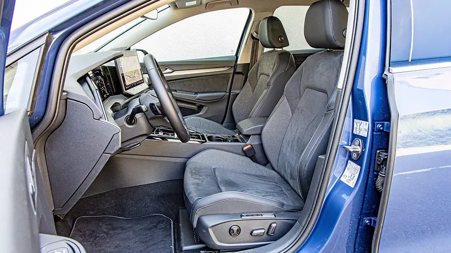 Blick durch die geöffnete Fahrertüre auf die Vordersitze im VW Golf Variant.